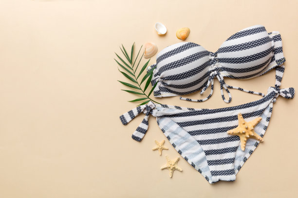 女子泳装和海滩配件平铺顶视彩色背景夏季旅行的概念。比基尼泳装，草帽和高跟鞋。复制空间俯视图图片下载