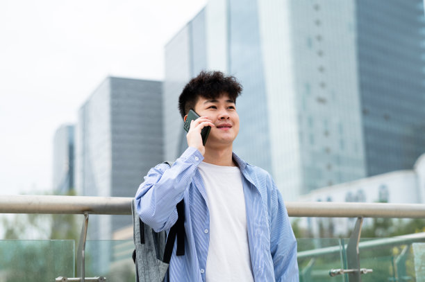 亚洲年轻英俊的大学生在城市街道图片下载