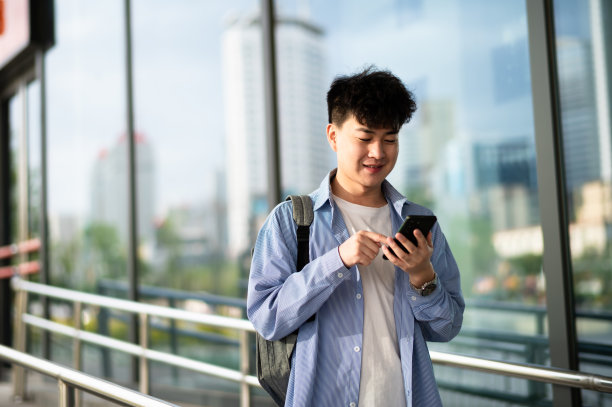 亚洲年轻英俊的大学生在城市街道图片下载