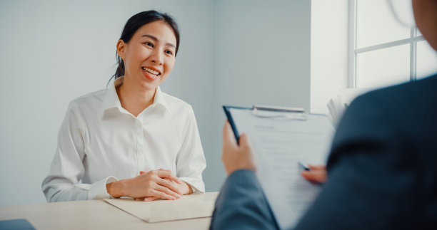 年轻的女商人面试一份工作，同时在办公室讨论简历。图片下载