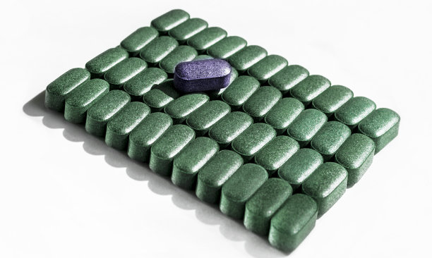 小球藻丸、螺旋藻丸、大麦草丸在白色底色上特写成行营养补充、排毒保健超级食品图片下载