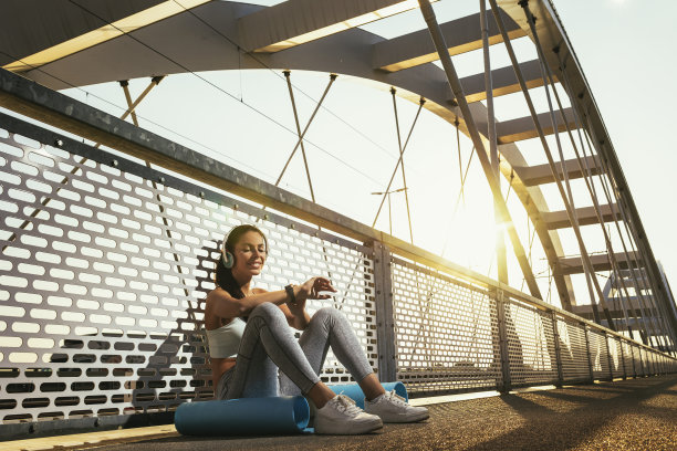 女子在桥上锻炼后用智能手表测量心率图片下载