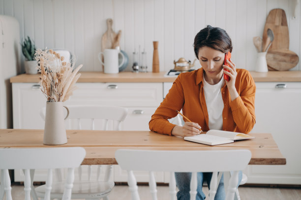 年轻女子是自由职业者。在家工作的女孩接到一个电话。检疫工作。图片下载