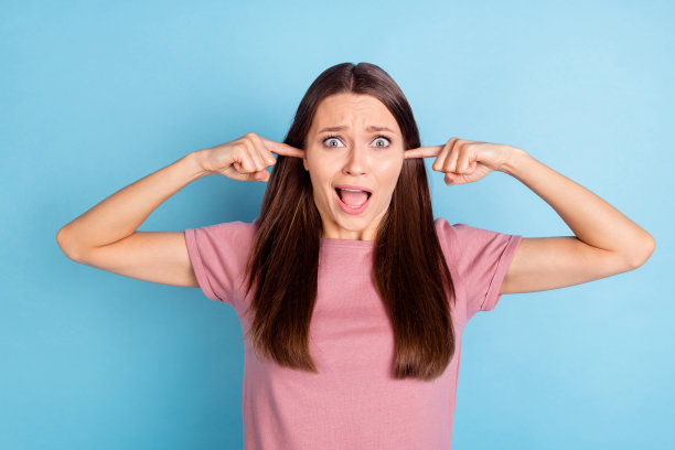 照片害怕不开心不安的年轻女子盖耳朵手指大声噪音孤立在柔和的蓝色背景图片下载