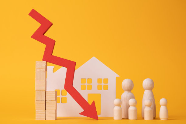 一个家庭的木制雕像和白色房子旁边的红色箭头。减少对一个年轻的大家庭的住房贷款的概念图片下载