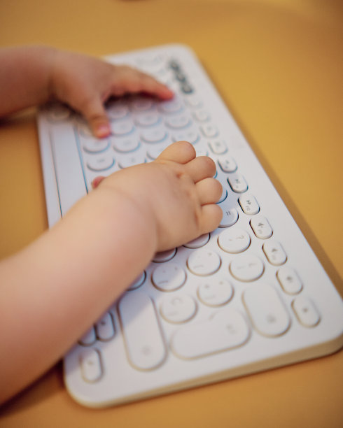 宝宝使用电脑键盘。手的特写细节。有选择性的重点图片下载