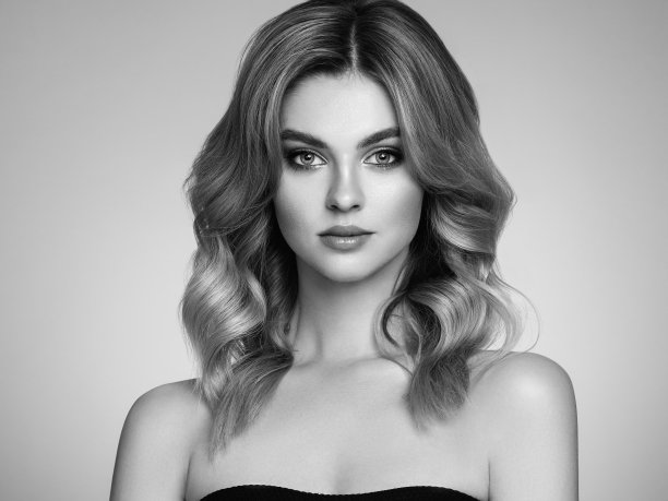 一个漂亮的年轻女人，有一头闪亮的金色卷发图片下载