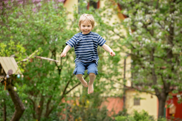 孩子，在蹦床上跳得很高图片下载