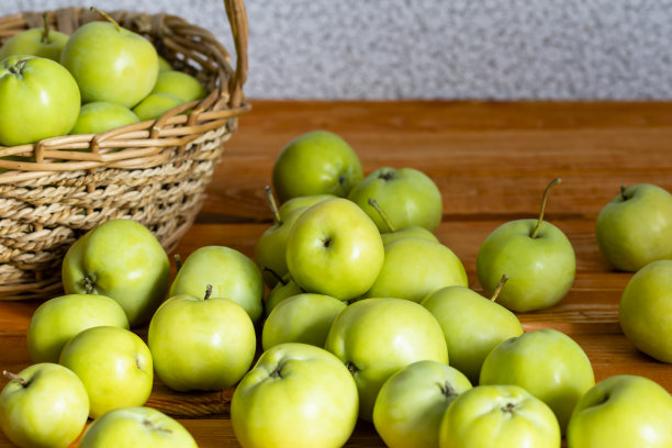 组成与多汁青苹果在柳条篮子上的桌子。本空间图片下载