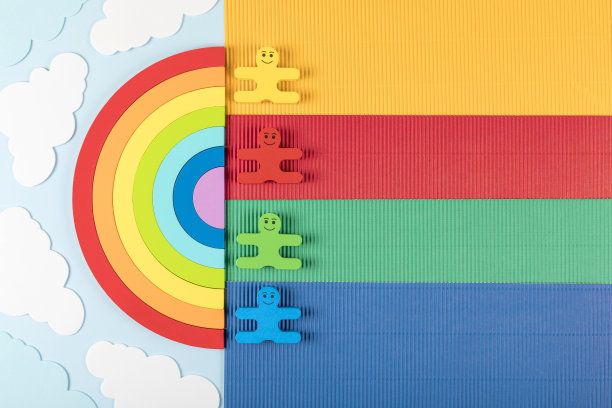 国际儿童节的概念。蓝色背景的彩虹上有孩子们的木制玩具。图片下载