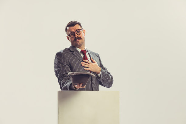 一个男人，商人穿着灰色条纹西装在五六十年代的时尚风格拿着帽子孤立在白色背景。复古复古风格，商业，广告图片下载