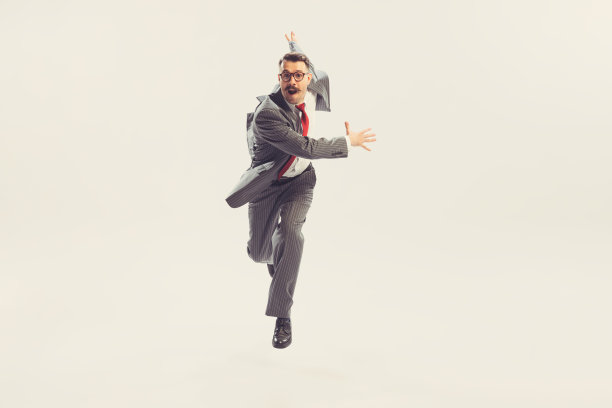 跑步男子，商人穿着灰色条纹西装在50、60年代的时尚风格hurring孤立的白色背景。复古复古的风格，商业，广告，情感图片下载