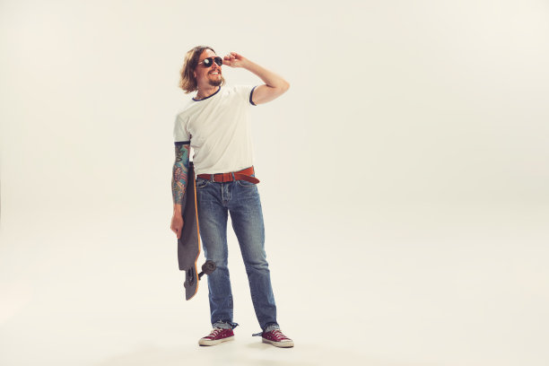 时髦的年轻人，时髦的穿着五六十年代的时尚风格与长板孤立在白色背景摆拍。复古复古的风格，商业，广告，情感图片下载
