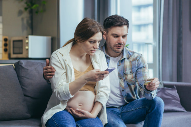 担忧，年轻家庭，孕妇和丈夫拿着信用卡和手机，查询账单，无法理解，致电银行图片下载