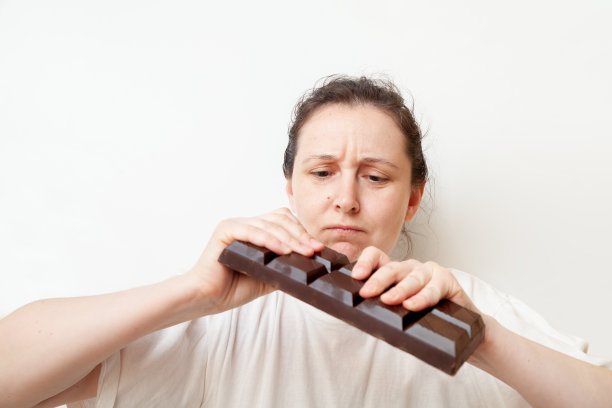 一个年轻女子打碎了一大块巧克力图片下载
