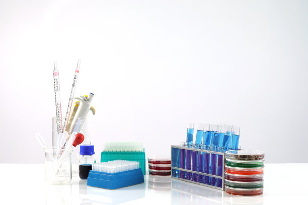 实验室用化学管和玻璃器皿放置显微镜台面，科研技术台面白色背景图片下载