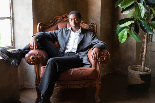 非裔美国妇女的肖像，在沙发上摆姿势图片下载