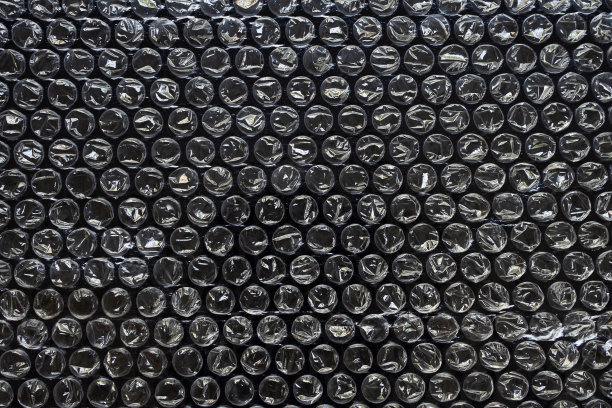 塑料膜气泡包装材料在黑色背景上叠加纹理图片下载