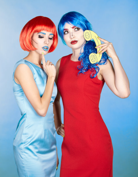 年轻女性的肖像在漫画流行艺术化妆风格。戴红色和蓝色假发的女性打来电话图片下载
