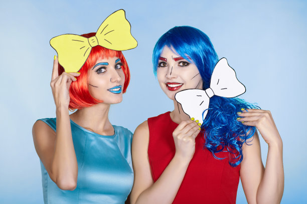 女性戴着红色和蓝色的假发，蓝色的背景。拿着黄色领结的女孩图片下载