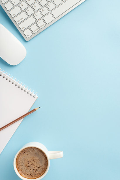 经营理念。俯视图垂直的工作站的照片，键盘，电脑，鼠标，咖啡杯，记事本和铅笔在孤立的淡蓝色背景图片下载