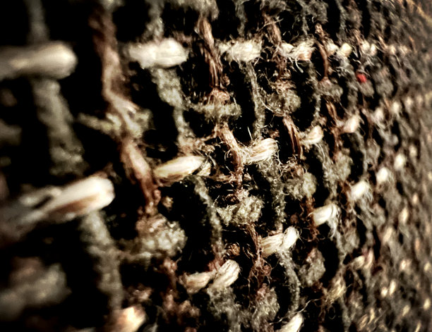 暗光粗糙织物的微距图像。图片下载