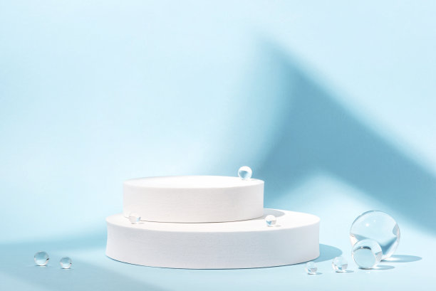 白色的讲台上有蓝色背景的玻璃球。图片下载