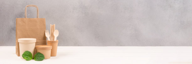 纸制的食物容器，袋子，杯子，吸管和木制餐具，以灰色的墙壁为背景，带有副本空间。可持续食品包装理念的旗帜。环保餐具图片下载