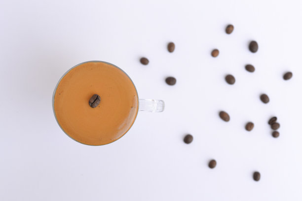 航拍的用咖啡豆装饰的杯子里的咖啡图片下载