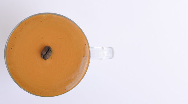 航拍的用咖啡豆装饰的杯子里的咖啡图片下载