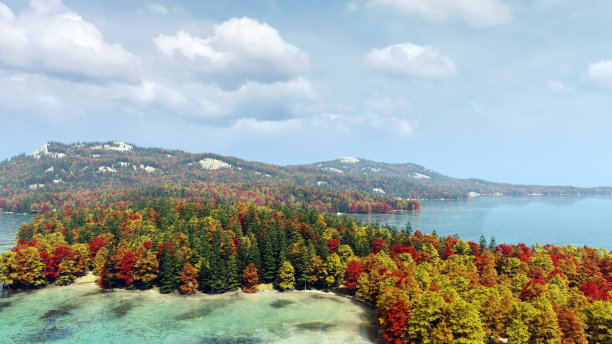 山与秋天的森林和蓝色的湖泊下的蓝色多云的天空。3 d渲染。图片下载