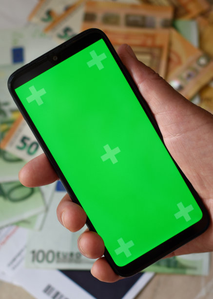 老妇人手里拿着布满皱纹的手机和彩色按键屏幕。背景是欧元现金和希腊电费。垂直的特写照片。有选择性的重点图片下载