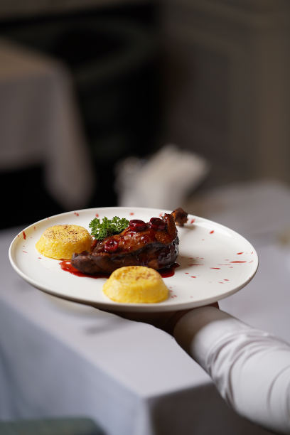 白盘子里放着鸭腿和玉米粥图片下载