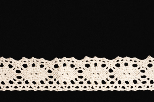 黑色背景上的白色花边与复制空间水平隔离。关闭了。缝纫的概念图片下载