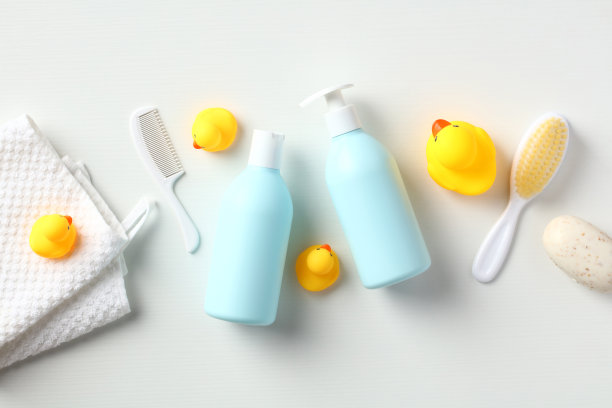 成套新生儿洗发香波，沐浴露，毛巾，黄色橡皮鸭，沐浴刷，肥皂，梳子在白色的桌子上。宝宝日常护理理念。平铺，俯视图。图片下载