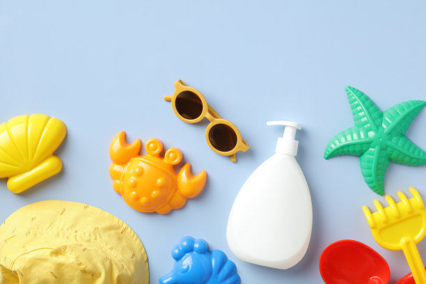 婴儿防晒霜模型与巴拿马帽，太阳镜，沙子模具在蓝色的背景。防晒乳液瓶设计、品牌化。图片下载