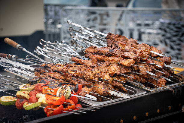 堆烤腌猪肉串肉与烤蔬菜串在户外烧烤架上图片下载