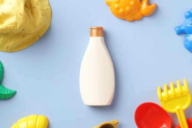婴儿防晒霜模型与巴拿马帽和沙子模具在蓝色的背景。防晒乳液瓶设计、品牌化。图片下载