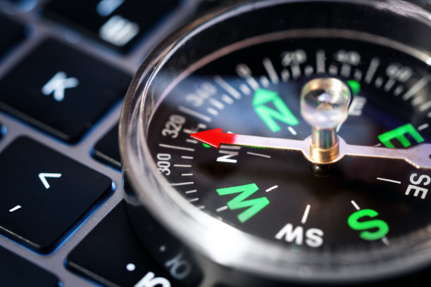 正确方向的想法。面向业务发展理念，指南针放在笔记本电脑键盘上。近景与焦点对指南针针。图片下载