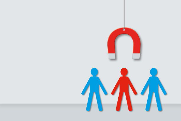 磁铁吸引着灰墙背景上的红纸人。员工招聘的概念。图片下载