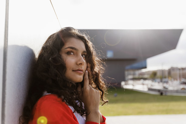 特写一个快乐的年轻女人在城市户外打电话图片下载