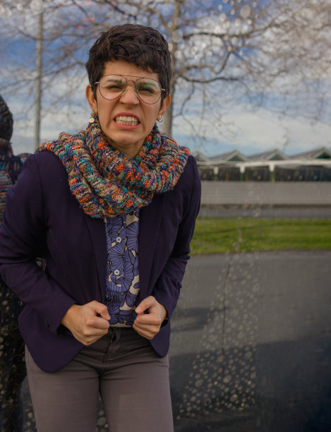 愤怒的短发女人穿着西装外套和围巾，脸上的表情不舒服图片下载