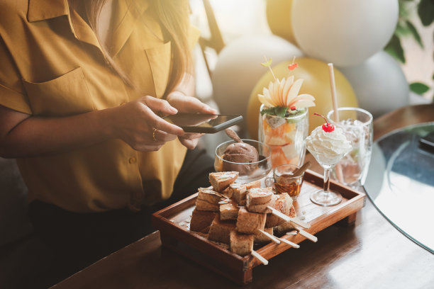 女人准备拍摄蛋糕和饮料。图片下载