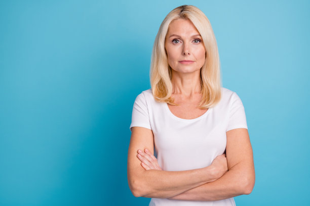 严肃聪明的老太太交叉双手的照片穿好看的衣服隔离在蓝色的背景图片下载