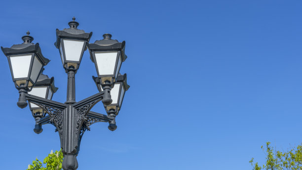 复古街灯在蓝天和绿树的背景。特写镜头。老式的lampost。空间的文本。图片下载