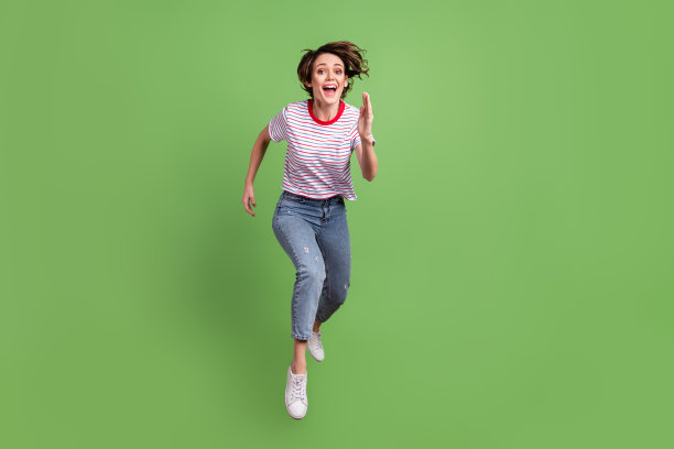完整的身体尺寸的看法漂亮开朗的女孩跳跑运动孤立在绿色柔和的颜色背景图片下载