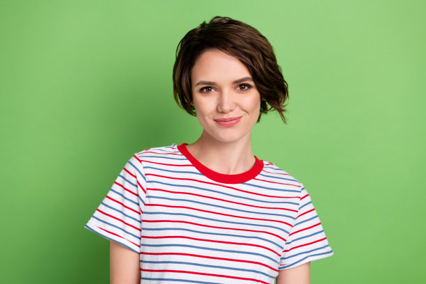 照片华丽满意的女士微笑看相机穿蓝色红色条纹装孤立在绿色背景图片下载