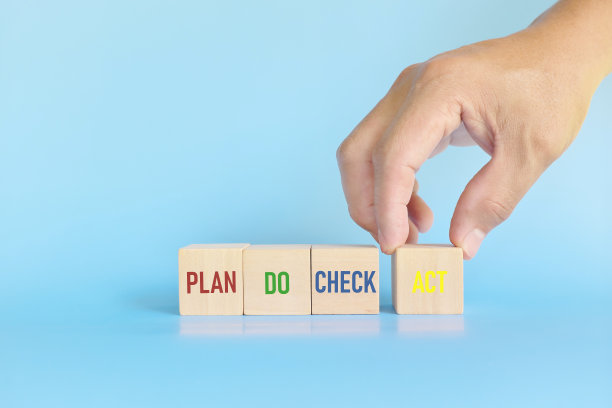 PDCA或计划实施检查行动循环方法的概念。手把行动木块在蓝色的背景与复制空间。图片下载