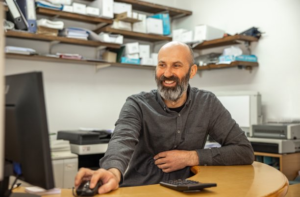 白人男子在复印店工作，同时使用电脑图片下载