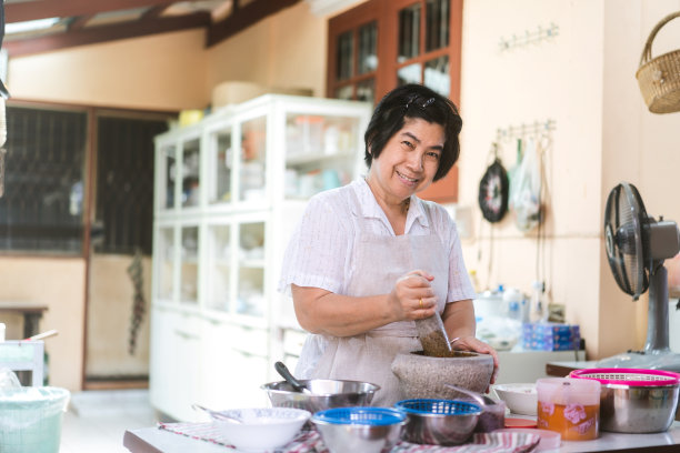 真实肖像亚洲老年妇女烹饪当地传统泰式食物。图片下载